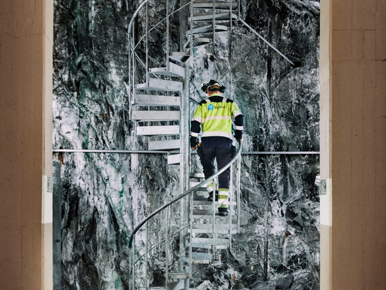 Man walking up stairs inside power plant